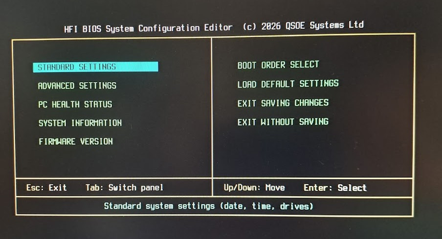 Photograph of the HFI BIOS System Configuration Editor: a two-panel Set-Up screen — Standard Settings, Advanced Settings, PC Health Status, System Information and Firmware Version on the left; Boot Order Select, Load Default Settings and the exit options on the right.